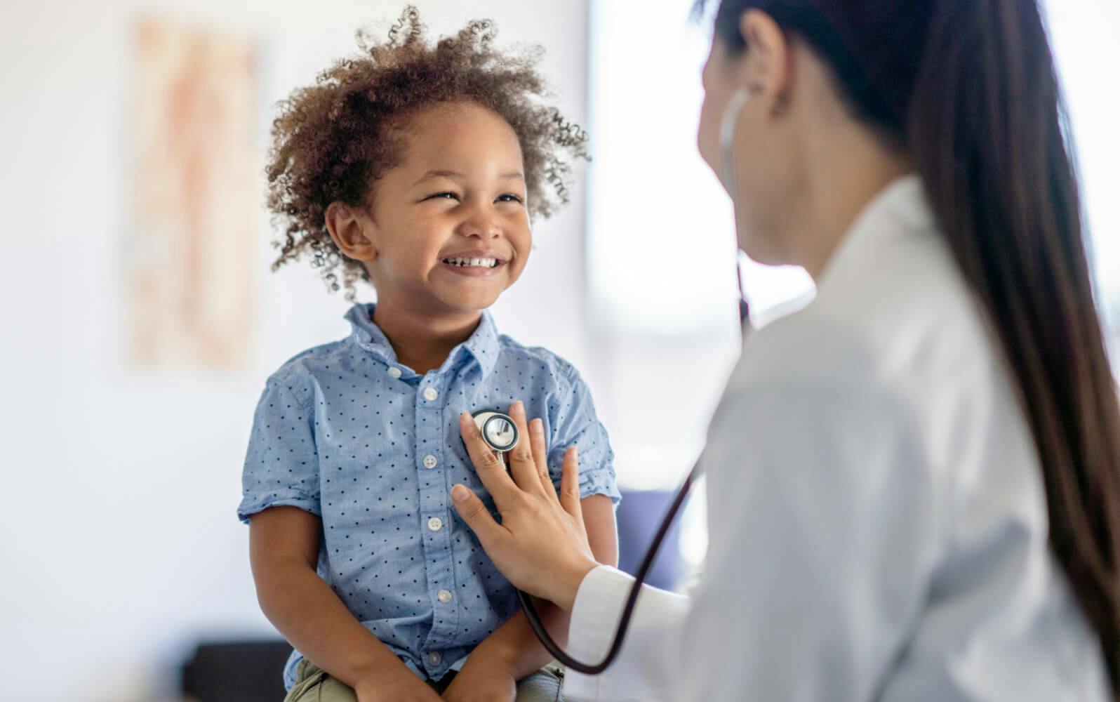 A healthcare professional examining a toddler