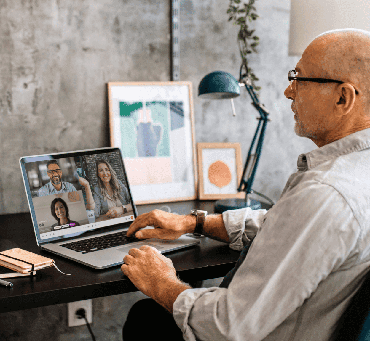 A man attending a video conference meeting on a laptop