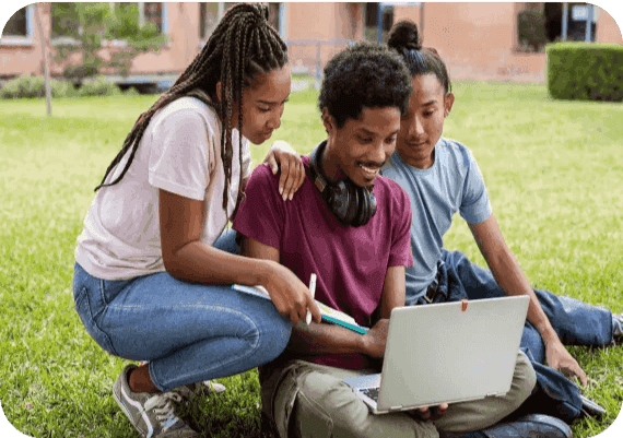 Three students viewing a laptop